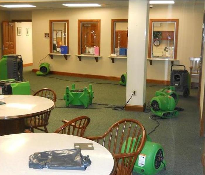 waiting room with green carpet and green SERVPRO equipment setup on the floor