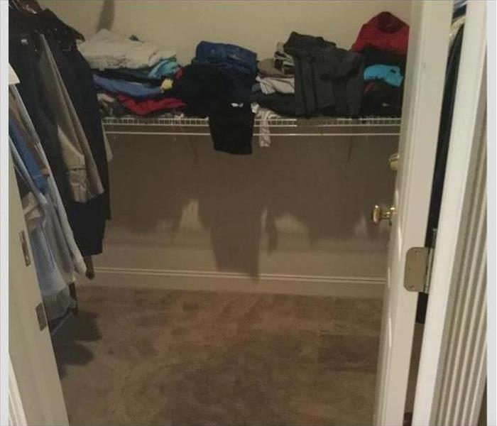 close with cloths handing and folder on the shelf with wet carpet