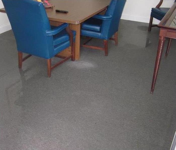 office with wet grey carpet, blue chairs and wood tables