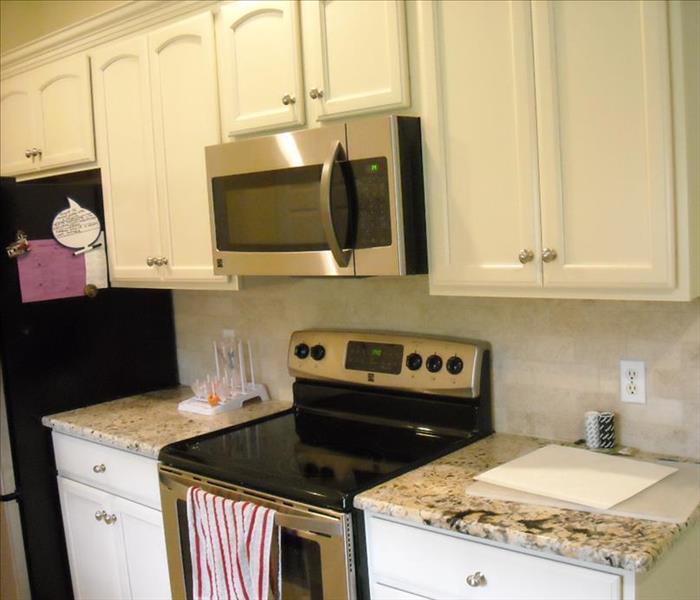 kitchen with white cabinets an black and silver appliances