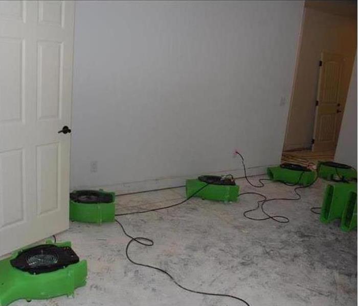 room with concrete floor with green equipment setup 