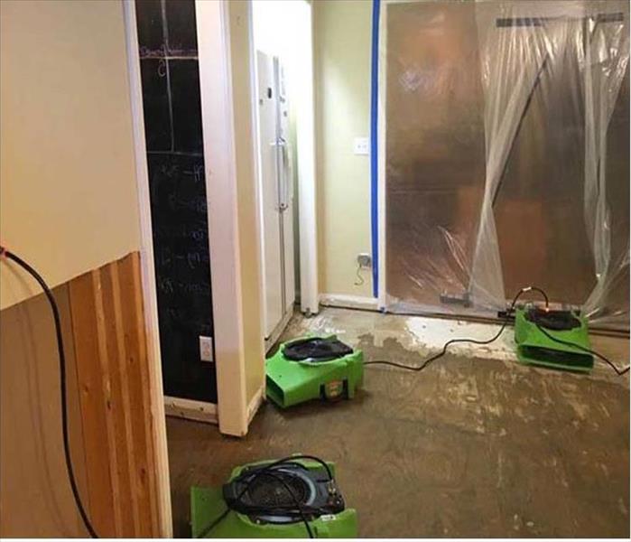 room in a home with subfloor exposed and SERVPRO equipment setup
