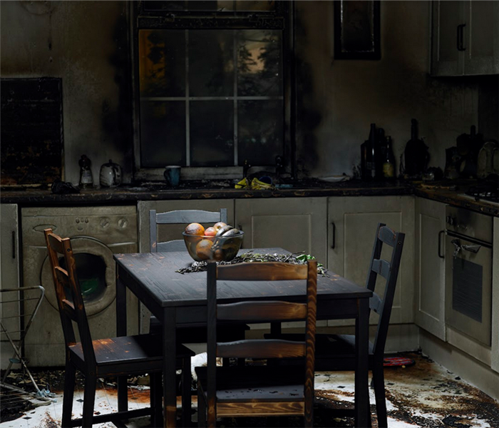 a fire damaged kitchen with soot covering the tables and counters