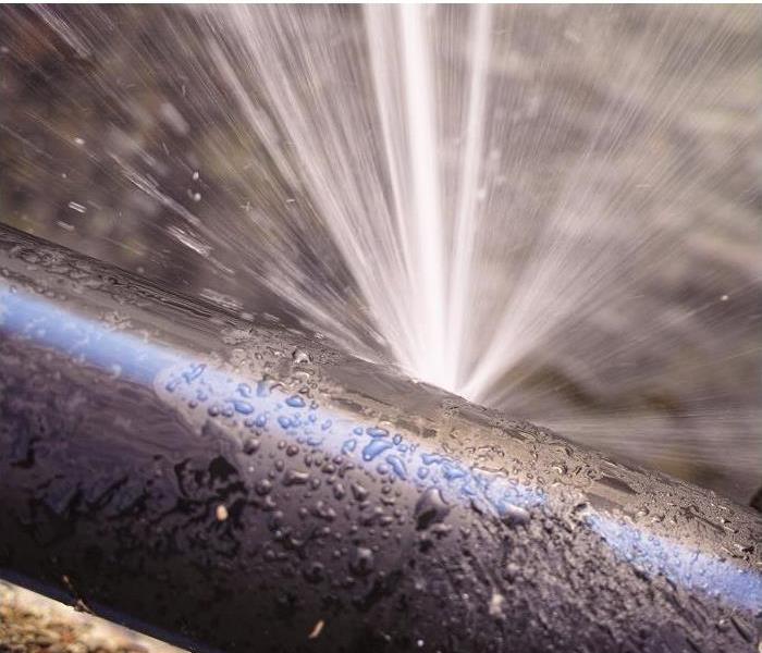 water spewing from small hole in pipe