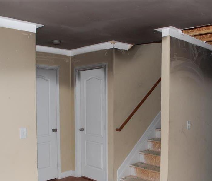 hallway and staircase with tan walls covered in soot damage