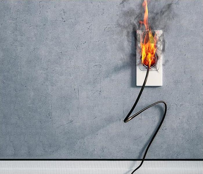 plug on fire on a grey wall