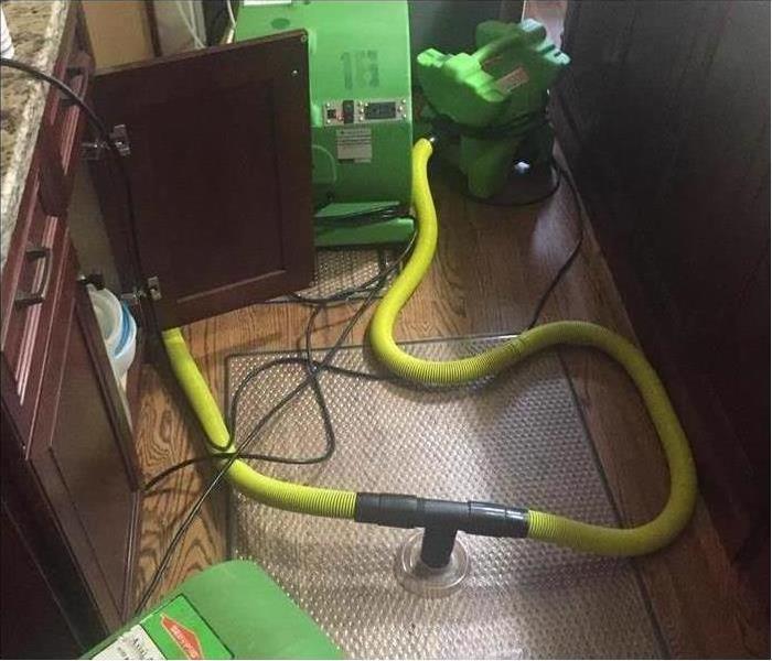 A hardwood mat extractor sucking up water in the kitchen of a home
