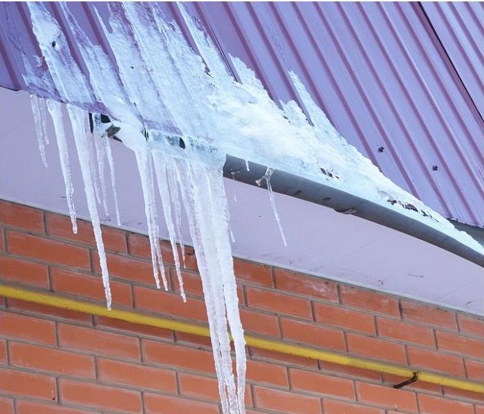 ice forming in rain gutter and roof