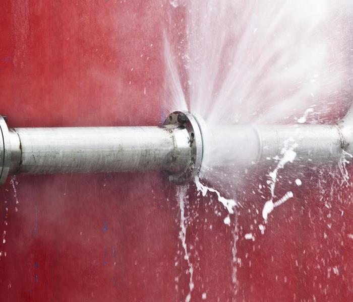 A burst water with a red wall 