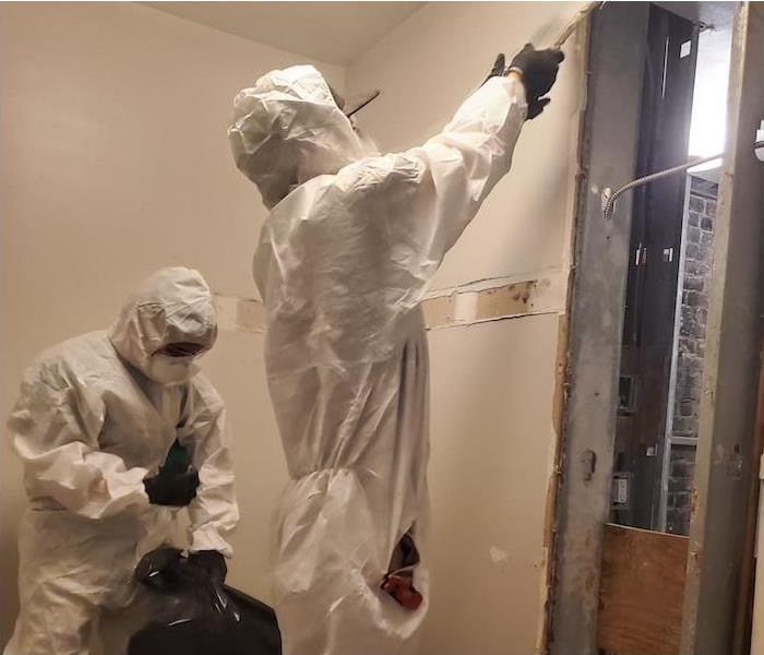 employees in PPE setting up a containment barrier